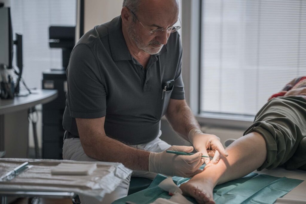 Dr. Paul Müller untersucht den Knöchel eines Patienten