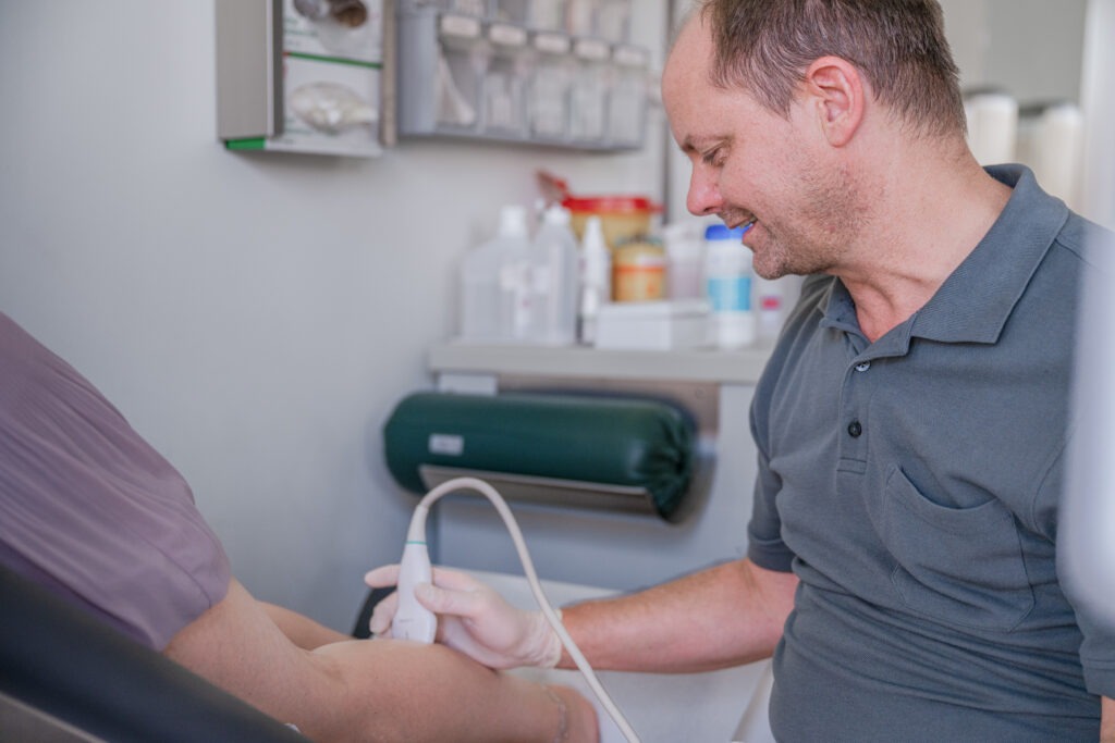 Dr. Claus Urbahn mit Ultraschallgerät am Patientenarm